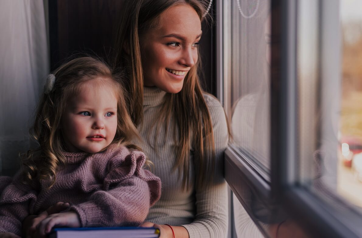 beautiful-mother-with-daughter-family-sitting-in-the-room-near-window-looking-outside-quarantine-time-3